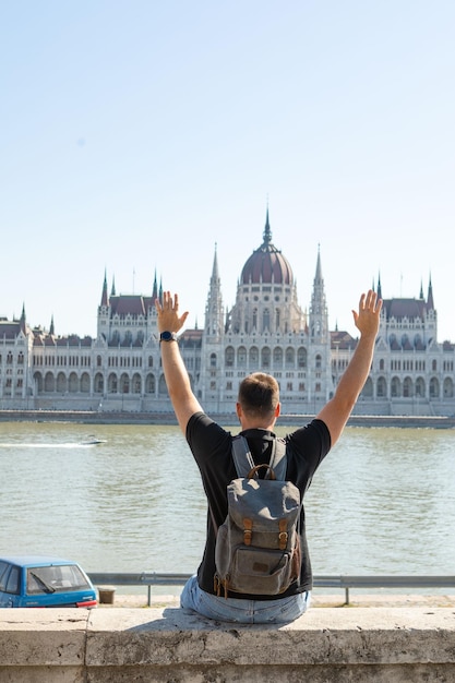 Homem viajante em frente ao edifício do parlamento de Budapeste