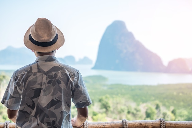 Homem viajante feliz aprecia o ponto de vista da baía de Phang Nga, Tailândia