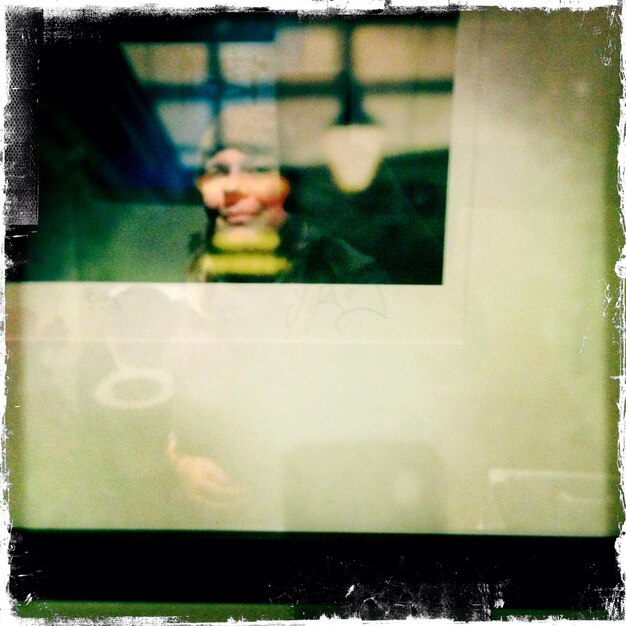 Foto homem visto através de uma janela de vidro em casa