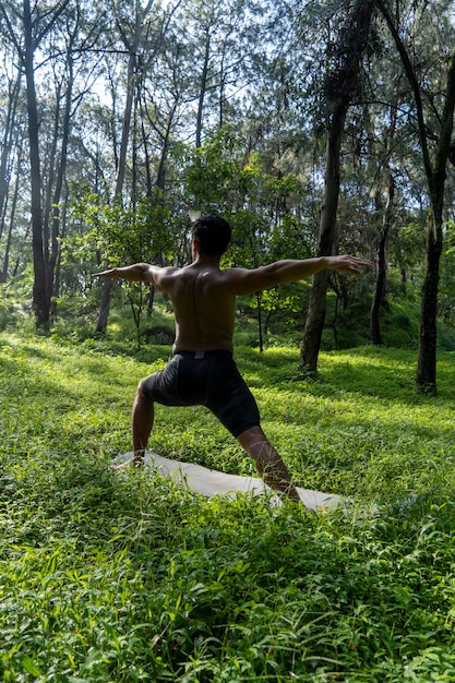 Homem visto de perto sem camisa fazendo alongamentos no tapete de ioga exercício américa latina