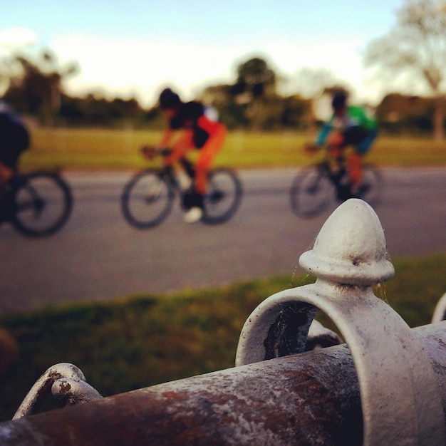 Foto homens a andar de bicicleta na estrada contra o céu