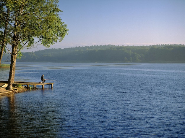 Foto homens a pescar no lago contra o céu