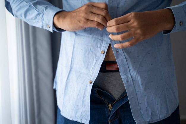 Homens abotoando camisa azul