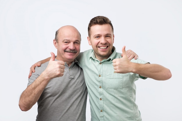 Foto homens abraçando e mostrando os polegares