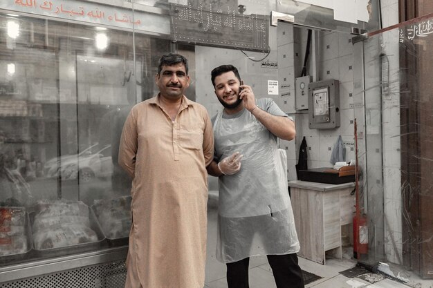 Foto homens árabes ao lado da loja no antigo mercado souk na cidade velha de jeddah, arábia saudita