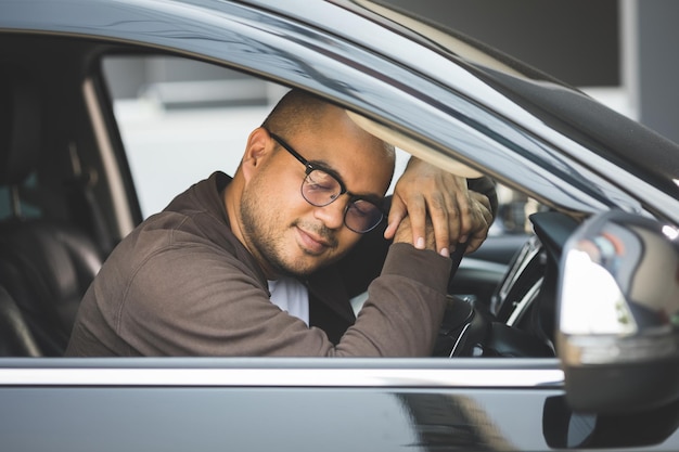 Homens asiáticos jovens em torno de 30 recebendo carro novo. Ele muito feliz e animado.