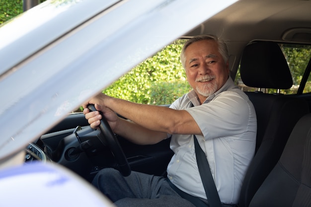 Homens asiáticos sênior dirigindo um carro e sorrir alegremente com expressão positiva contente durante a unidade para viajar viagem, as pessoas gostam de rir transporte e relaxado feliz homem maduro no conceito de viagem