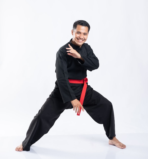 Homens asiáticos usam uniformes esportivos de silat pencak para lutar em branco