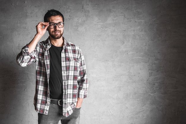 Homens com uma camisa xadrez em um fundo de parede de concreto cinza.