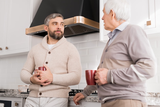 Foto homens conversando na cozinha