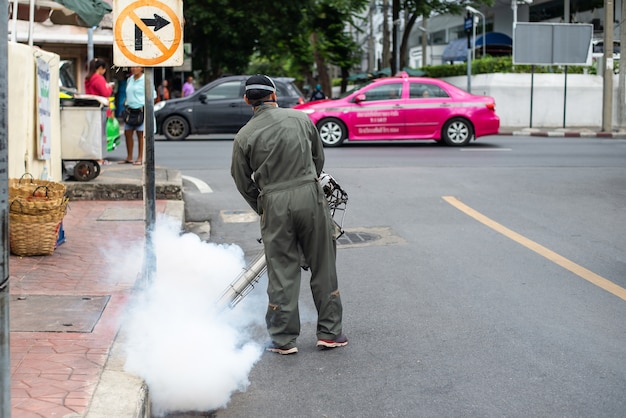 Homens correm neblina para eliminar mosquitos para prevenir a dengue