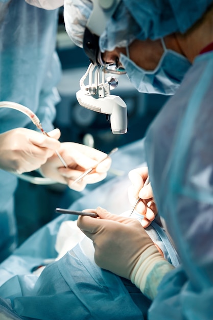 Homens da rinoplastia, as mãos enluvadas do cirurgião seguram os instrumentos durante a cirurgia de nariz. médico com luvas segura um instrumento médico durante a rinoplastia.