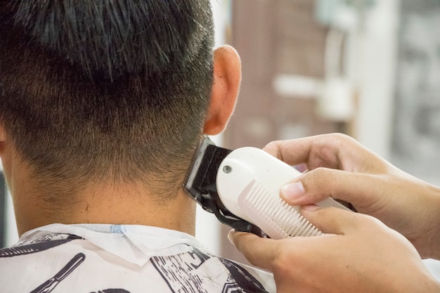 Homens de corte de cabelo barbearia. Cabeleireiro Masculino; barbeiros. Barber corta a máquina do cliente para cortes de cabelo.