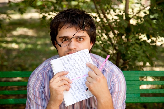 Homens de óculos fazendo lição de casa no parque.