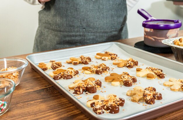 Homens de pão de gengibre com ponta de chocolate com coco torrado dourado