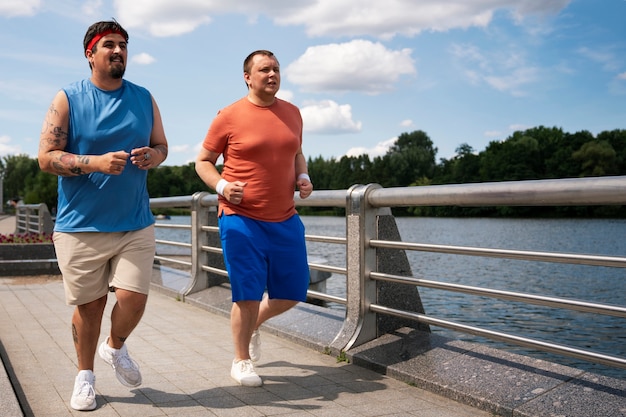 Homens de tiro completo se exercitando juntos ao ar livre