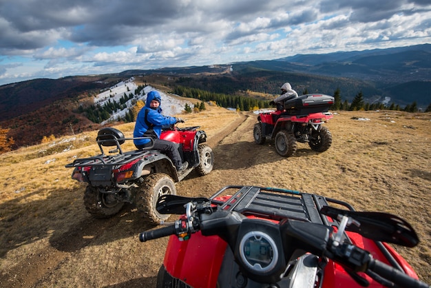 Foto homens dirigindo quad motos na frente no topo da montanha