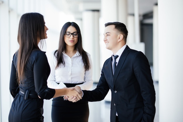 Homens e mulheres de negócios apertando as mãos, terminando uma reunião