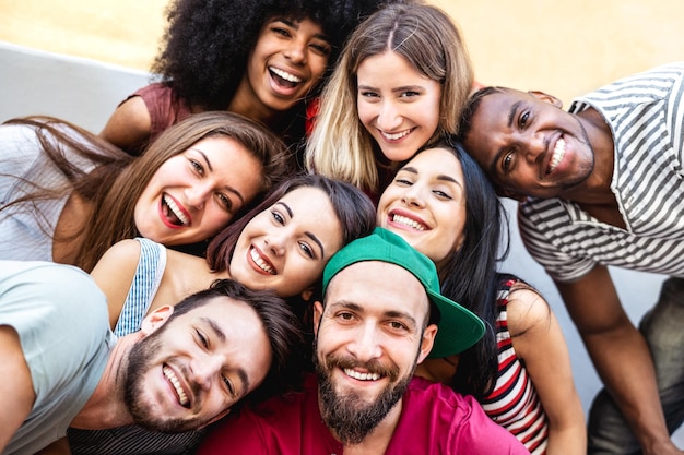 Homens e mulheres multiculturais tirando selfie lá fora