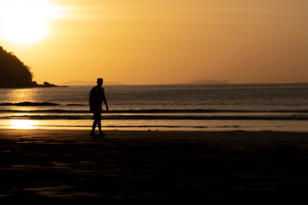 Foto homens e o pôr do sol no mar.