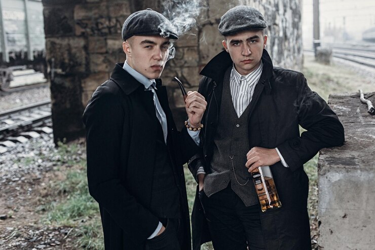 Foto homens elegantes de gângsteres fumando posando no fundo da ferrovia com garrafa de álcoolsherlock holmes e doutor watson inglaterra no tema dos anos 1920