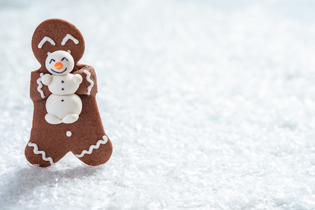 Homens engraçados de biscoitos de gengibre com boneco de neve de maçapão minúsculo