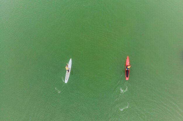 Homens fortes flutuando em pranchas de SUP em uma bela baía em um dia ensolarado Vista aérea dos homens atravessa a baía usando o paddleboard Competições de esportes aquáticos