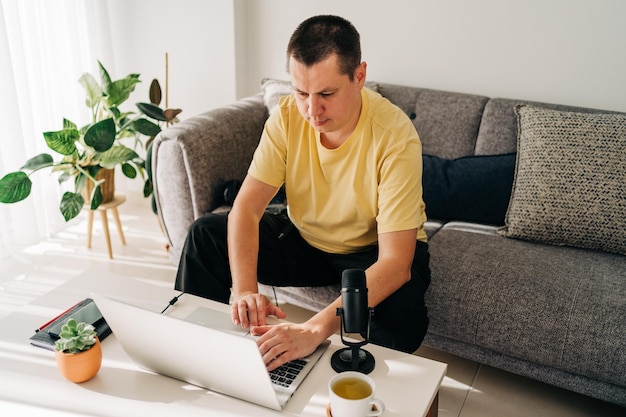 Foto homens freelancer com microfone digitando em laptop trabalhando de escritório em casa programadores sentados em