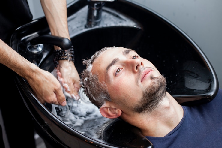 Foto homens lavam os cabelos em uma barbearia