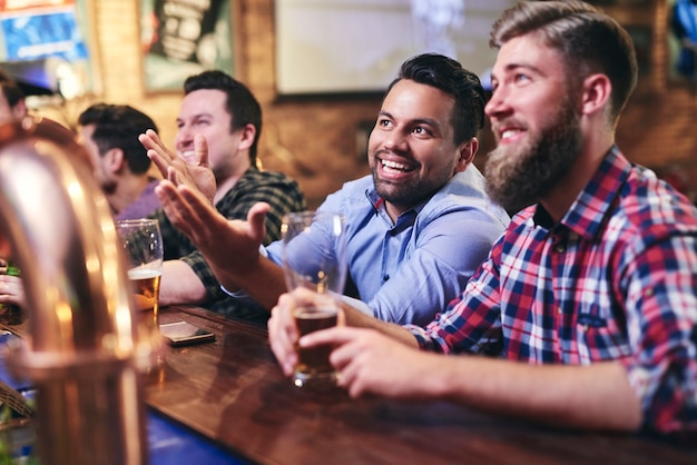 Foto homens maduros assistindo ao jogo de futebol no bar