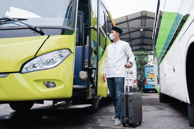 Homens muçulmanos viajam de ônibus público durante pandemia usando máscara