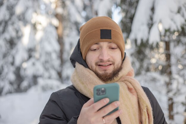 homens na floresta de inverno segurando o telefone celular nas mãos