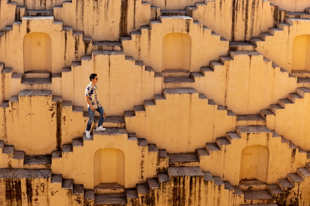 Homens que cruzam os poços em degraus de chand baori em jaipur na índia.