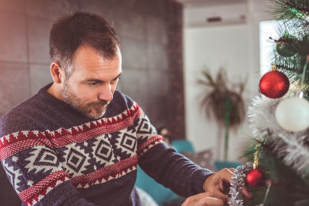 Homens que decoram a árvore de natal