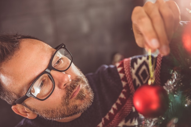 Homens que decoram a árvore de natal