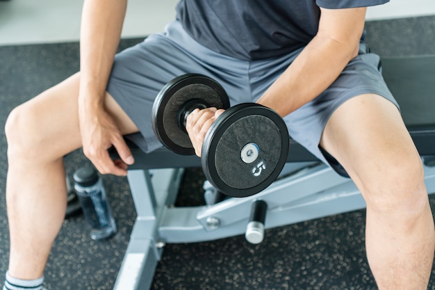 Homens que levantam pesos do dumbbell que preparam-se para o exercício na aptidão.