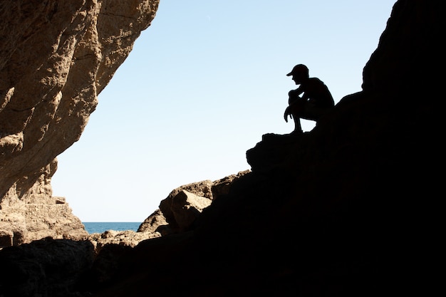 Homens recortados em uma pedra na luz de fundo