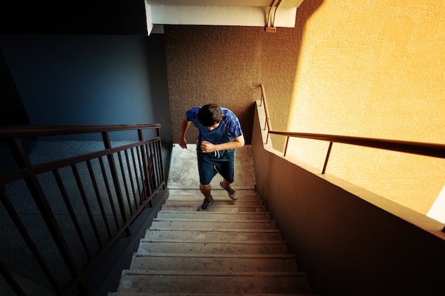 Homens se exercitando subindo e descendo escadas de concreto durante o sol da manhã.