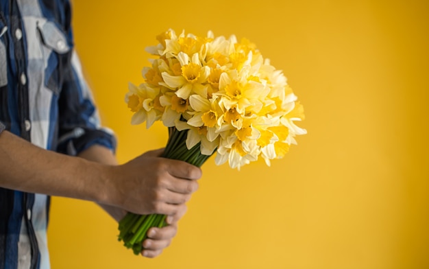 Homens segurando um grande buquê de narcisos.