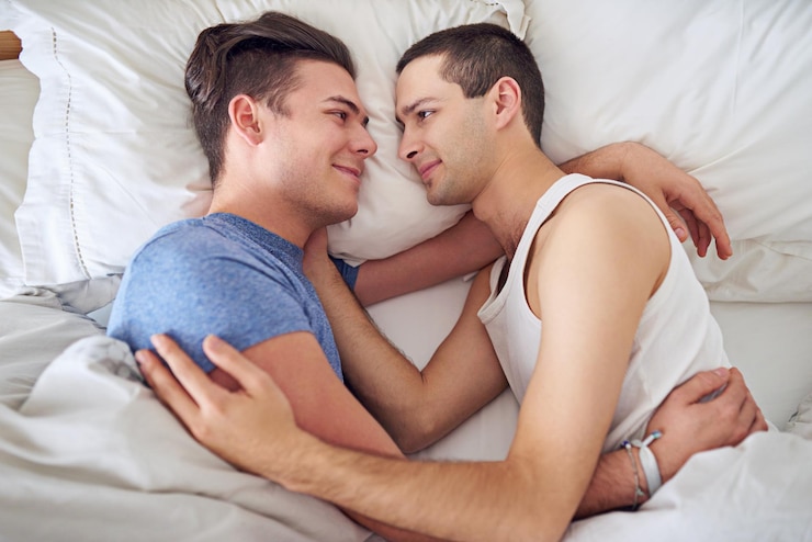 Foto homens sorridente e vista superior de casal gay na cama em casa para relaxar abraço e ligação juntos na manhã lgbtq acima e pessoas felizes no quarto para conexão de amor e relacionamento saudável