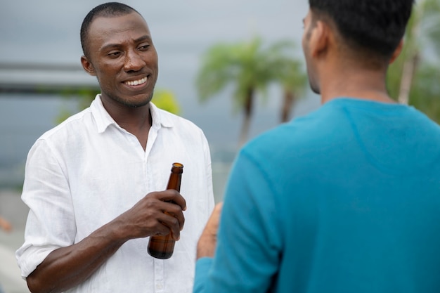 Foto homens sorridentes de vista lateral com bebidas