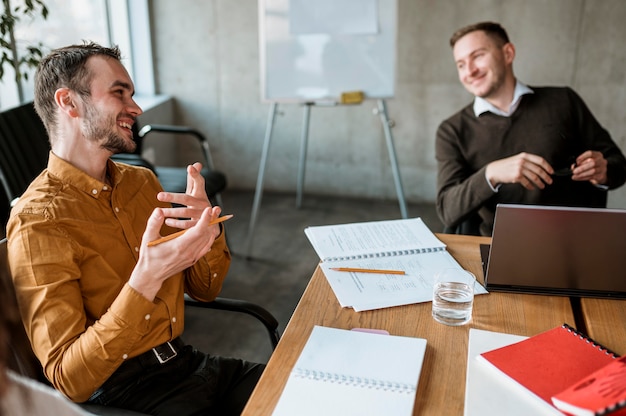 Homens sorridentes em reunião no escritório