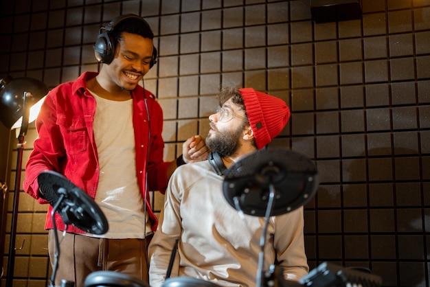 Homens tocando bateria elétrica em casa sstudio