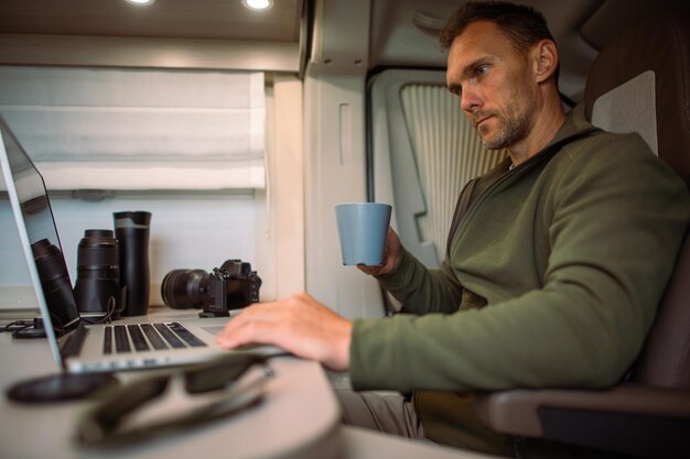 Foto homens trabalhando enquanto viajam em sua caravana