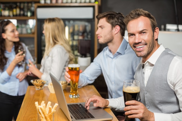 Homens trabalhando no laptop, enquanto as mulheres falam por trás