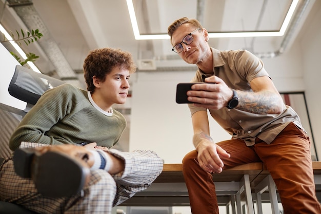 Homens usando smartphone no escritório