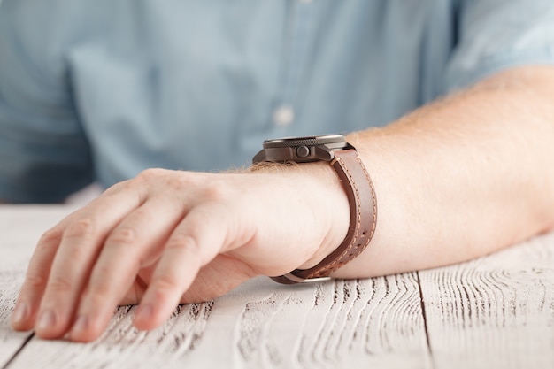 Homens usando um relógio preto com pulseira de couro preto sobre um branco