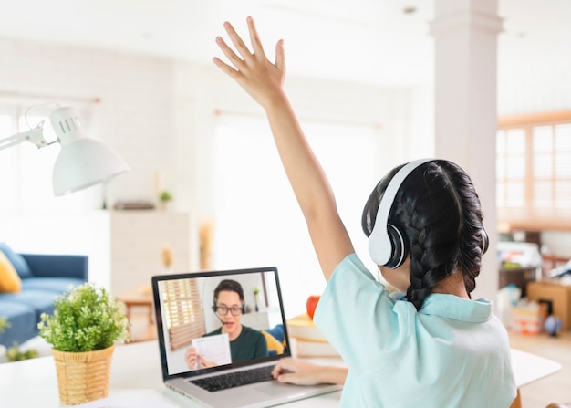 Homeschool Asia pequeña estudiante de aprendizaje virtual de clases en línea de Internet en la mesa en casa. concepto de aprendizaje en línea a distancia. proteger de los virus COVID-19.