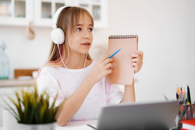 Homeschooled kleine junge Studentin mit Online-Unterricht mit digitalem Tablet