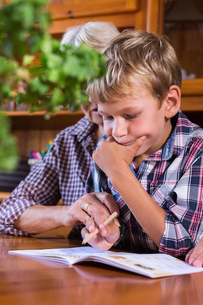 Homeschooling-Großmutter, die kluges Jungen-Kind-Kind unterrichtet